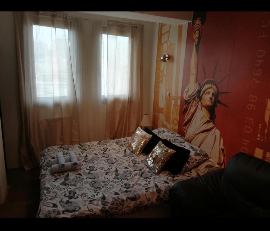 斯科普里的住宿－New York Apartment，卧室配有一张床铺,墙上挂着雕像