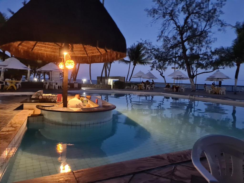 uma piscina no resort à noite em flat apt mobiliado beira mar no Recife