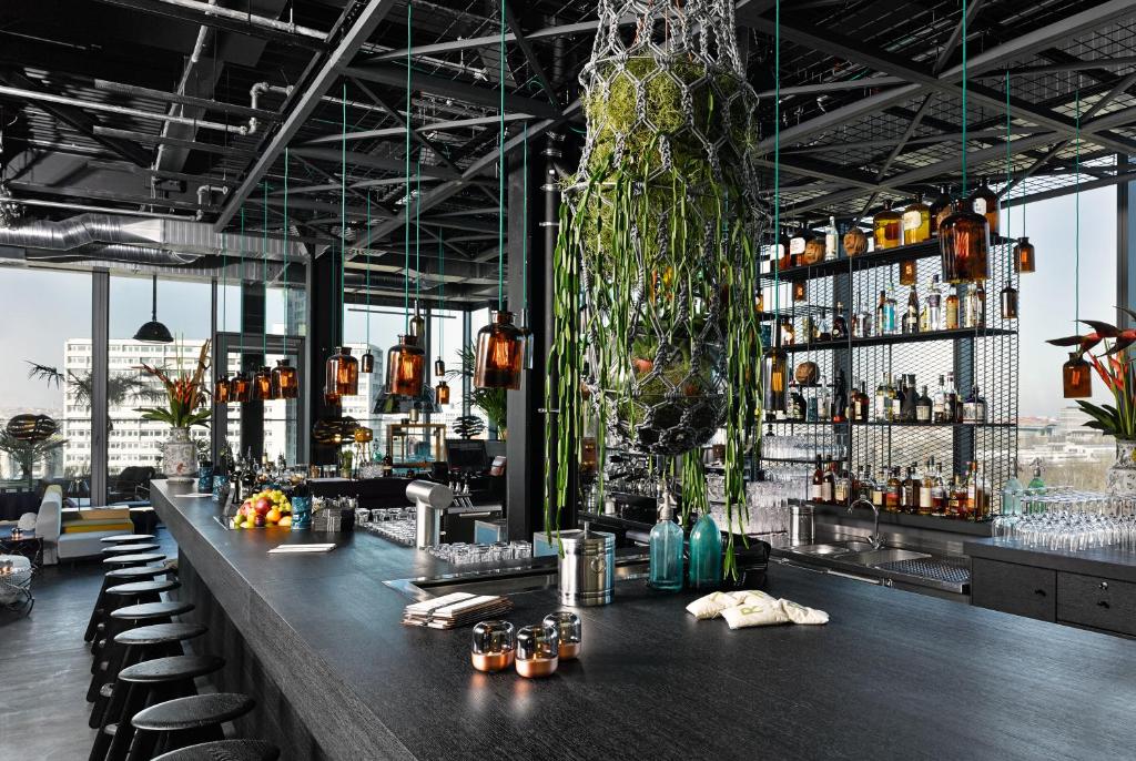 a bar with a long counter with stools at 25hours Hotel Bikini Berlin in Berlin