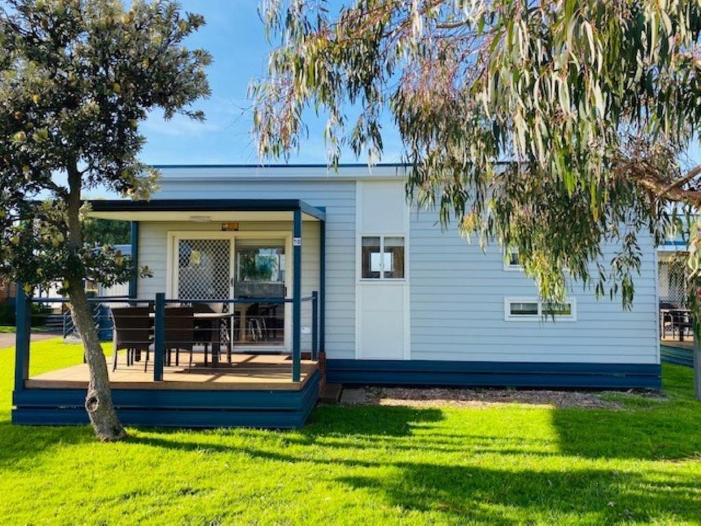 a house with a deck with a table on it at BIG4 Port Fairy Holiday Park in Port Fairy