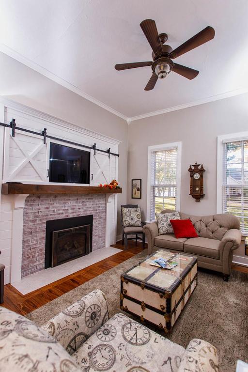 a living room with a fireplace and a ceiling fan at Cottage in Green Lake