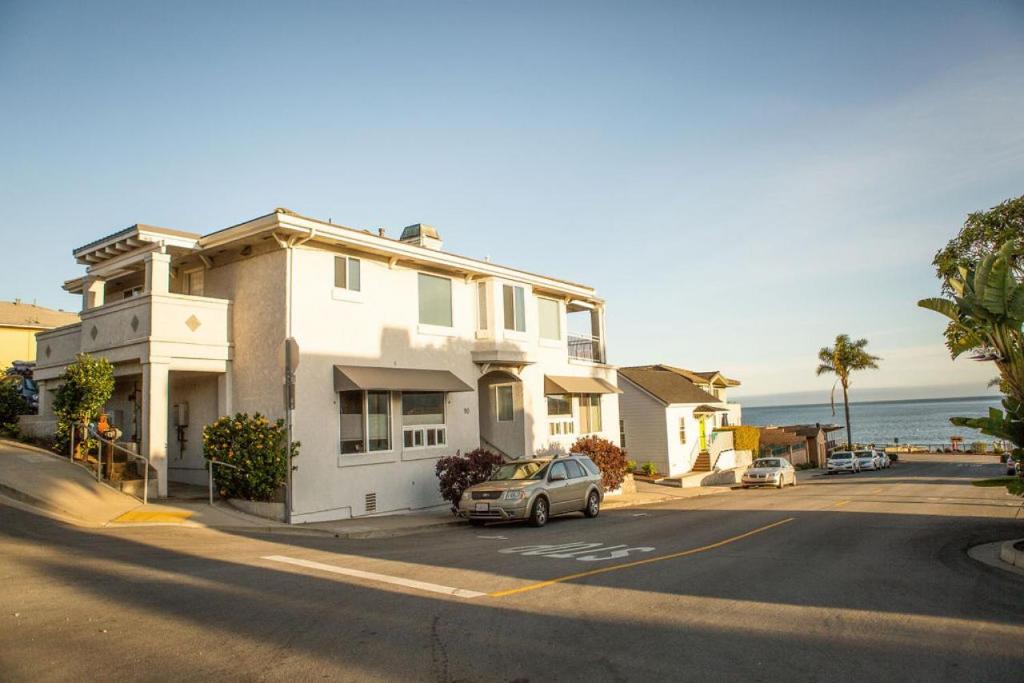 una casa blanca con un coche aparcado frente a una calle en 90 San Luis Street Unit A en Avila Beach