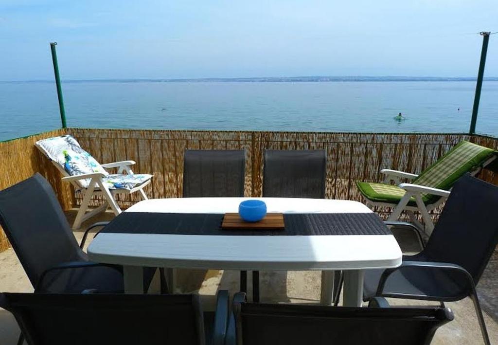 einen Tisch und Stühle mit Blick auf das Wasser in der Unterkunft Holiday home Villa Jadran - 10 m from beach in Preko