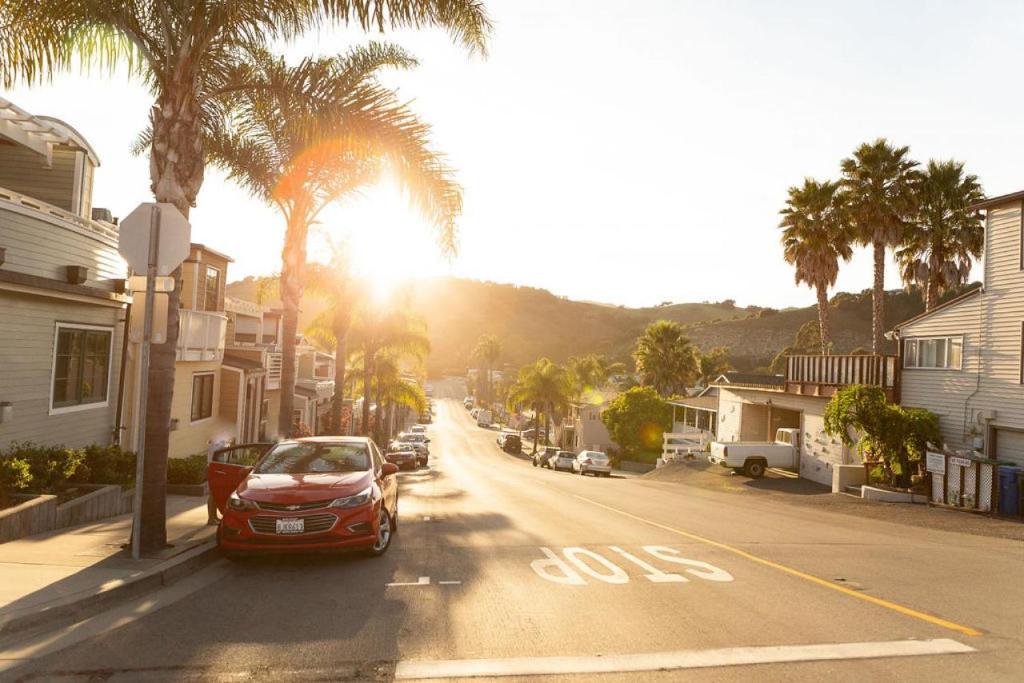 a red car driving down a street with palm trees at 90 San Luis Street Unit B in Avila Beach