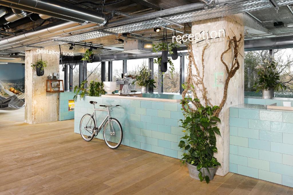 a bike parked next to a counter with plants at 25hours Hotel Bikini Berlin in Berlin