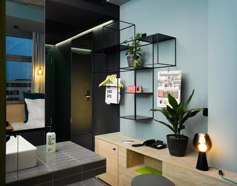 a room with a desk and a room with a bed at 25hours Hotel Bikini Berlin in Berlin