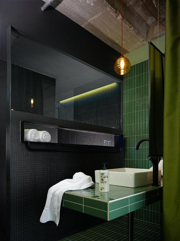 a bathroom with a sink and a mirror at 25hours Hotel Bikini Berlin in Berlin