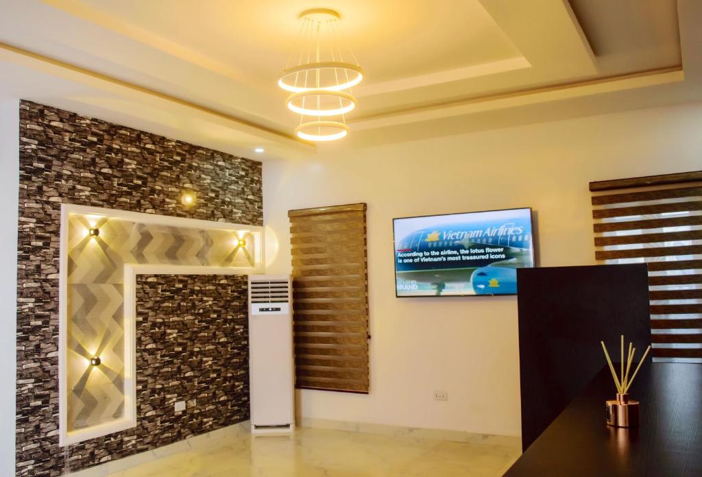 a living room with a tv and a wall at Ocean Park Hotel,Lekki phase 1 in Lekki