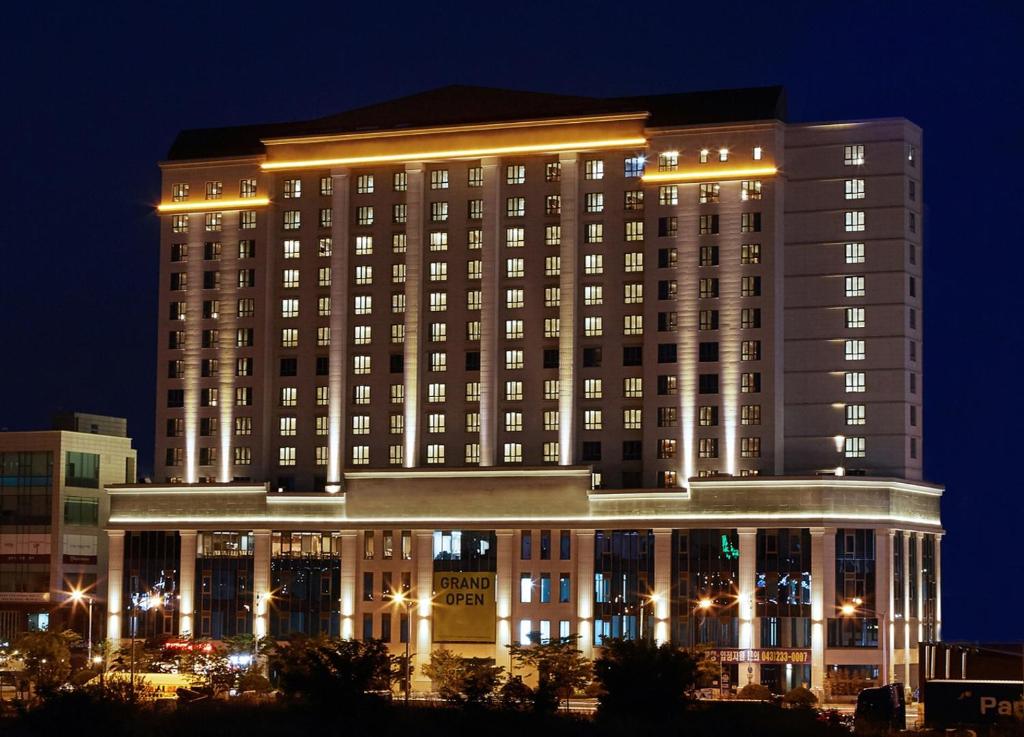 a large building with lights on it at night at Sejong City Osong Hotel in Cheongju