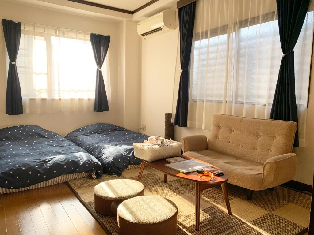 a bedroom with a bed and a chair and a table at Namio Apartment 201 in Tokyo