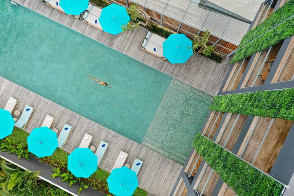 an overhead view of a pool with a person swimming in it at Citadines Berawa Beach Bali in Canggu