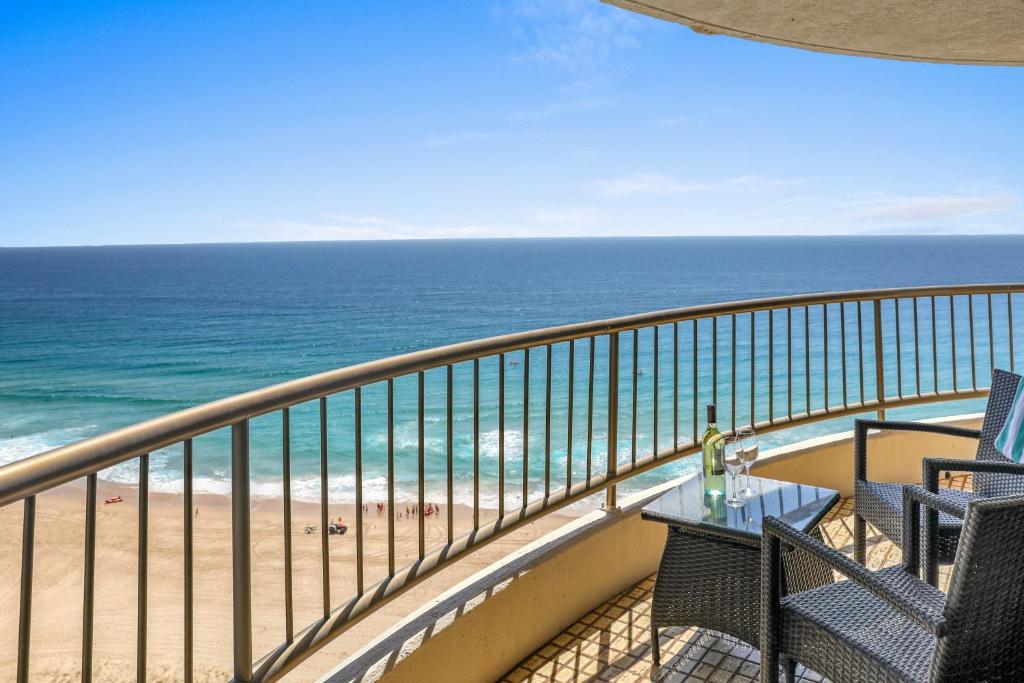 a balcony with a table and chairs and the ocean at Boulevard North Holiday Apartments in Gold Coast