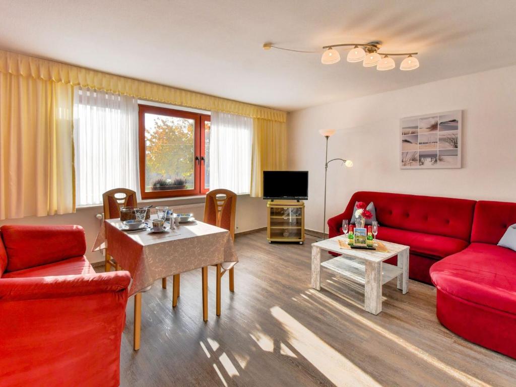 ein Wohnzimmer mit einem roten Sofa und einem Tisch in der Unterkunft Modern Apartment in Klutz with Sea Nearby in Klütz