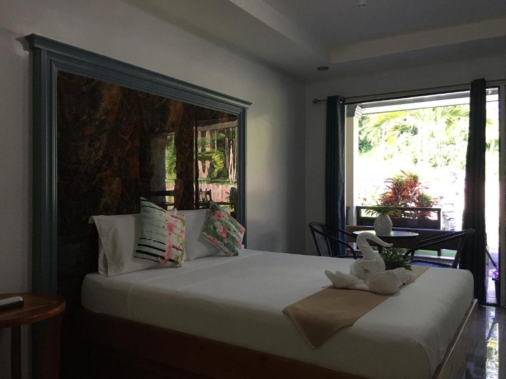 a bedroom with a bed with a large window at Aloha Seaside Resort in Siquijor