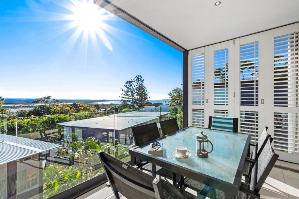 a dining room with a table and chairs on a balcony at The Rise Noosa in Noosa Heads