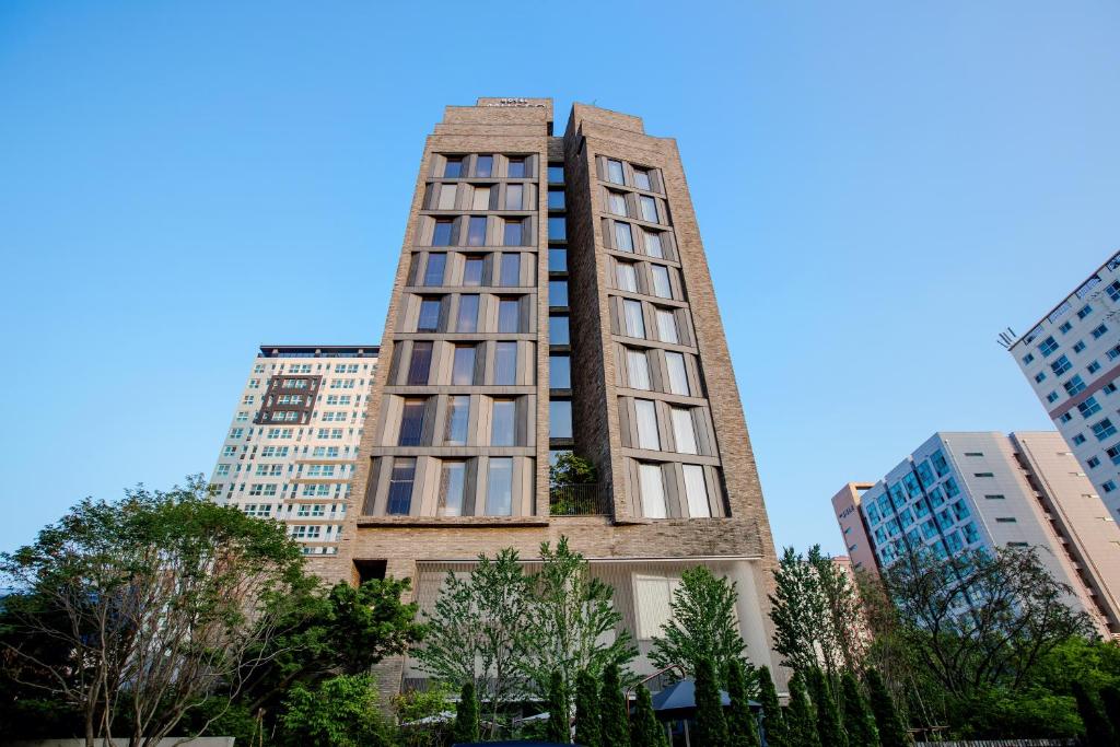 a tall building in the middle of some buildings at Hotel Museo Cheongju in Cheongju