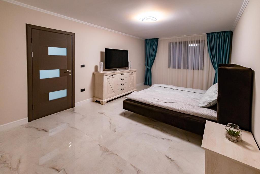 a bedroom with a bed and a flat screen tv at MOKY REZIDENT 2 in Arad