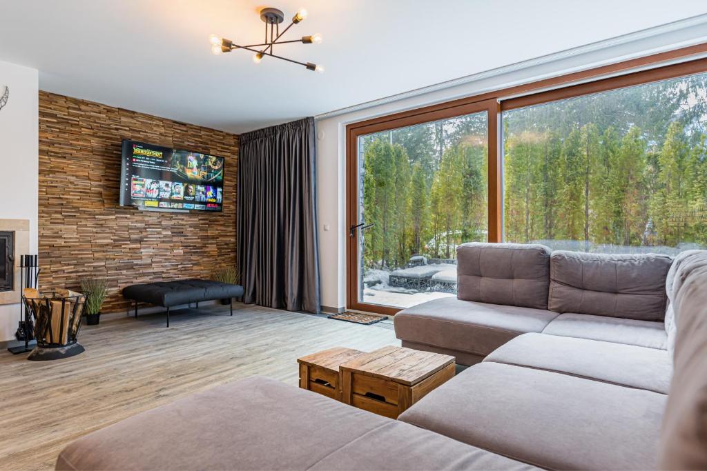a living room with a couch and a large window at Splendor 3 bedroom flat in Silver Mountain in Poiana Brasov