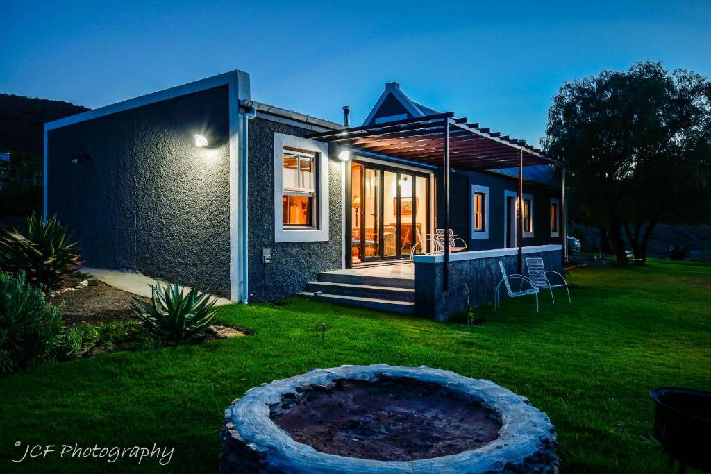 a small house with a large circle in the yard at Matjiesvlei Cottages in Calitzdorp