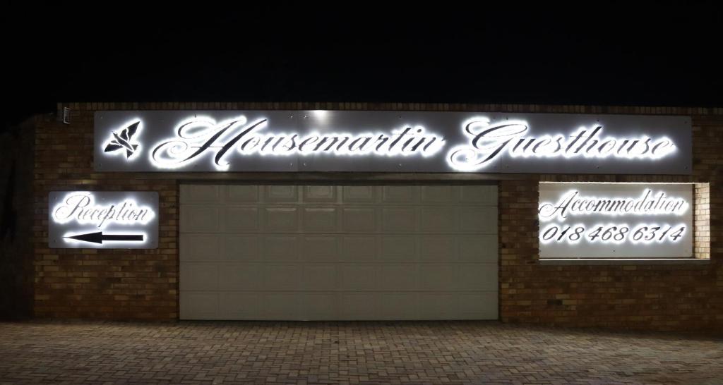 een winkel met neonlichten op de voorkant bij Housemartin Guest House in Klerksdorp