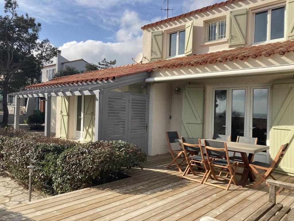 patio con tavolo e sedie su una terrazza di Villa de grand standing les Garrigues a Narbonne-Plage