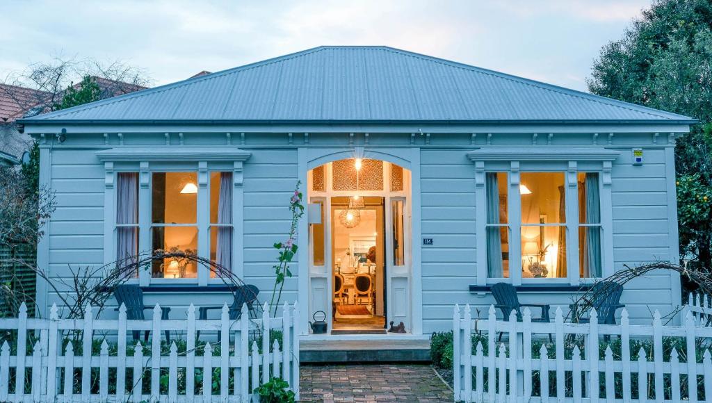 une maison bleue avec une clôture blanche dans l'établissement Villa Akaroa - Akaroa Pet Friendly Holiday Home, à Akaroa