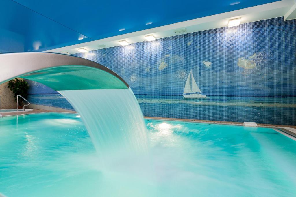 a swimming pool with a water fountain in a building at Rezydencja Bielik in Międzyzdroje