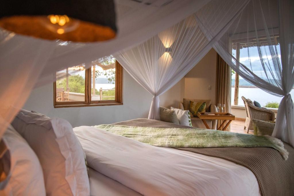 a bedroom with a canopy bed with a window at Manyara's Secret in Mto wa Mbu