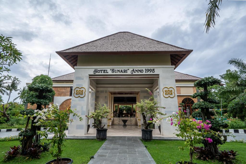 a front entrance to a resort with trees and flowers at New Sunari Lovina Beach Resort in Lovina