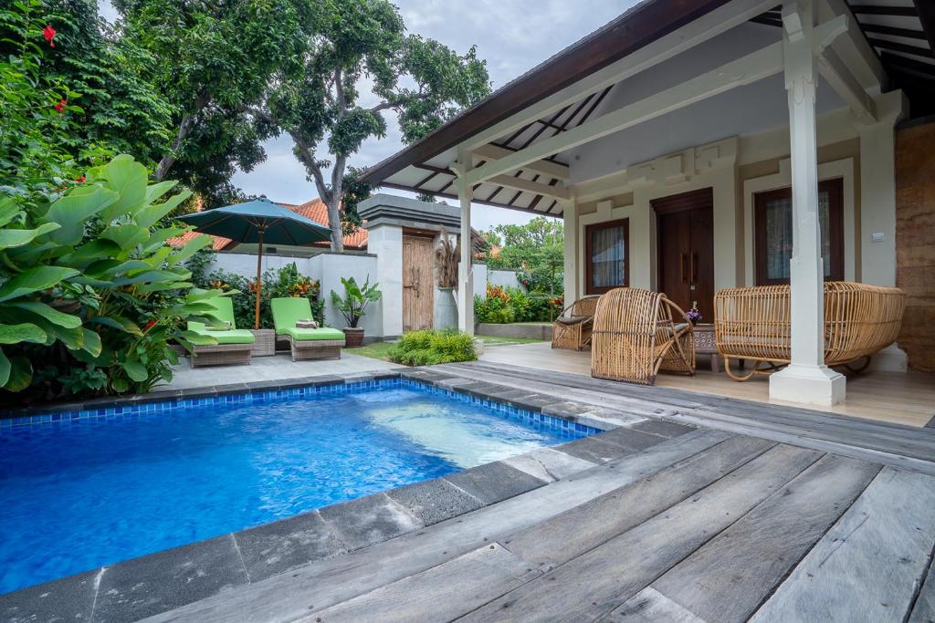 a patio with a swimming pool and a house at New Sunari Lovina Beach Resort in Lovina