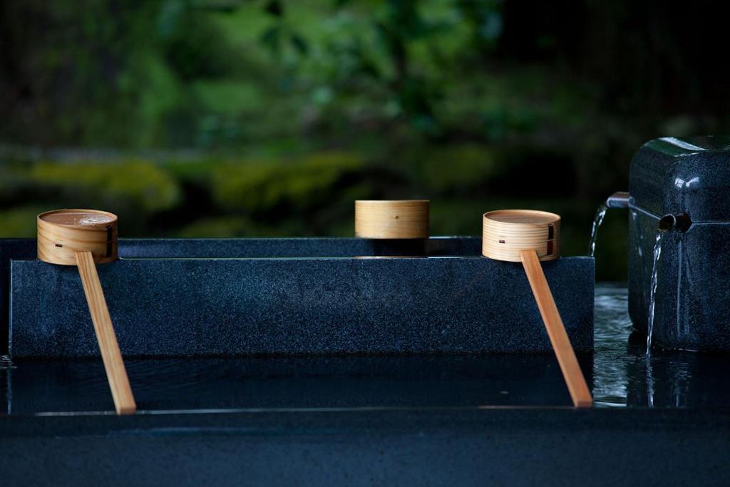 due spinelli di legno su un tavolo nero con due querce di B&B MIKAWA - Kanazawa Fish Harbour a Kanazawa