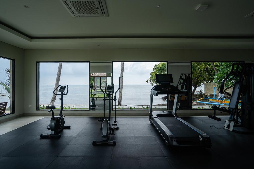 a gym with a view of the ocean with tread machines at New Sunari Lovina Beach Resort in Lovina