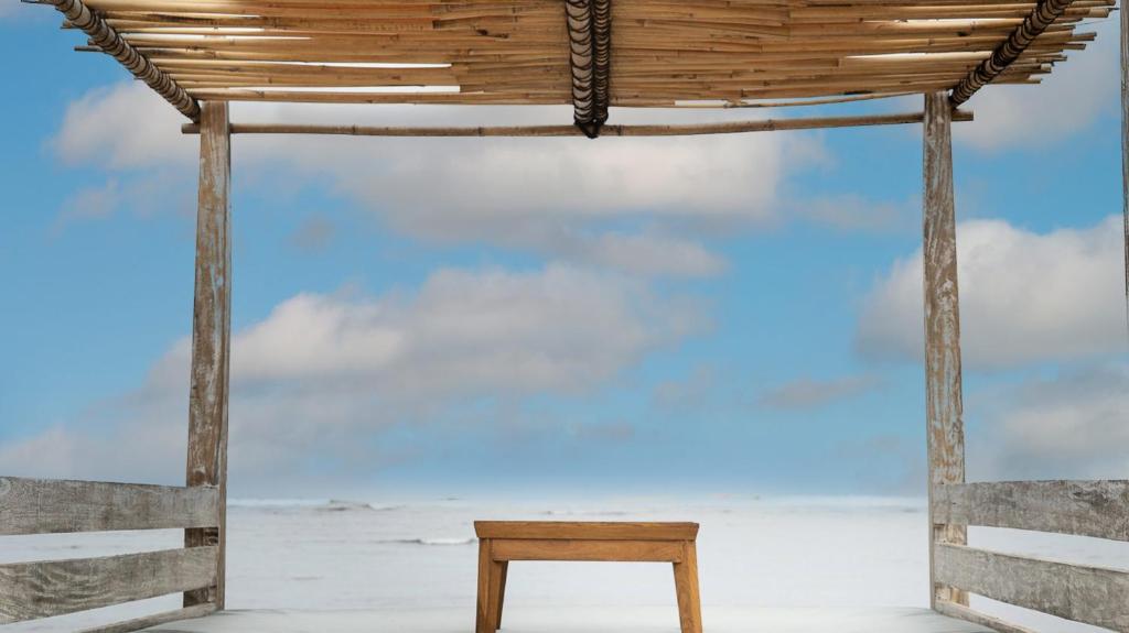 a wooden bench under a pavilion with the sky at New Sunari Lovina Beach Resort in Lovina