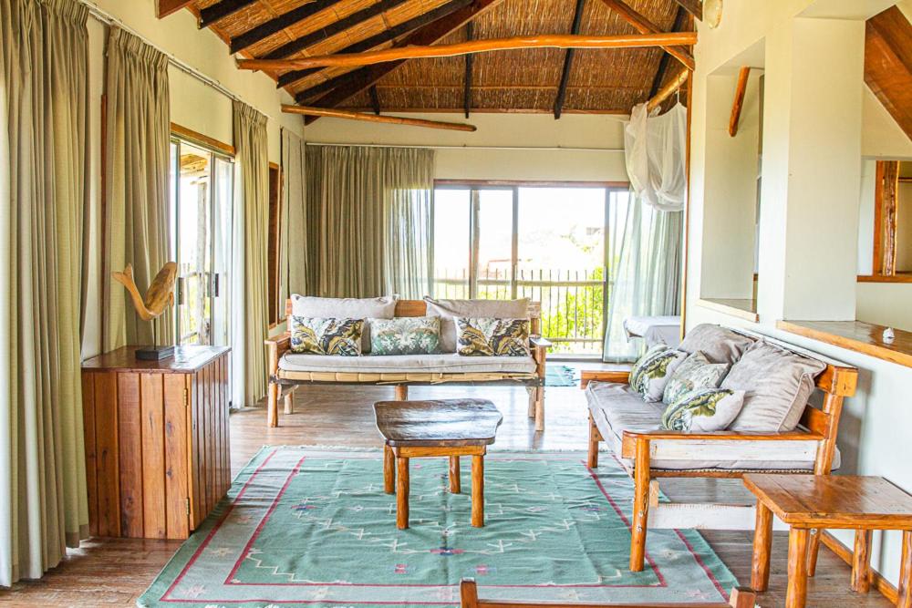 - un salon avec un canapé et une table dans l'établissement Tree House Villa, à Praia do Tofo