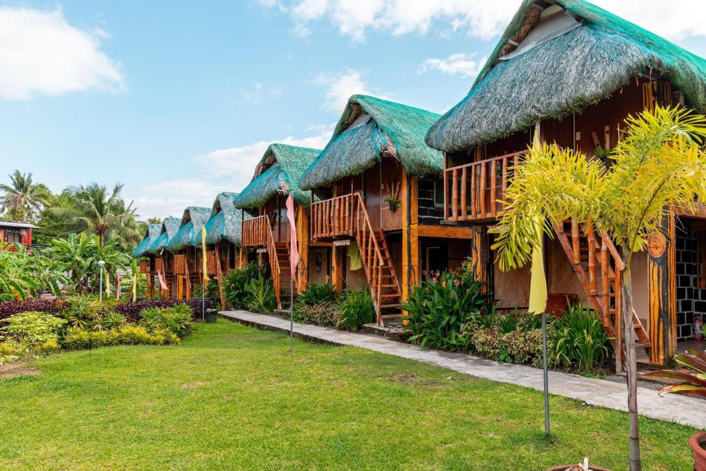 una fila de cabañas con techos de hierba en Your Brothers House Tribal Village en Legazpi