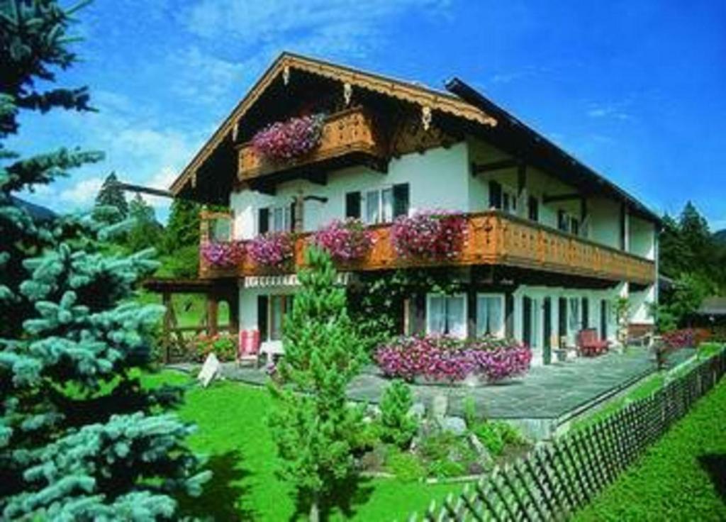 una casa grande con flores en la parte delantera en Gästehaus Ulrich Neuner en Wallgau