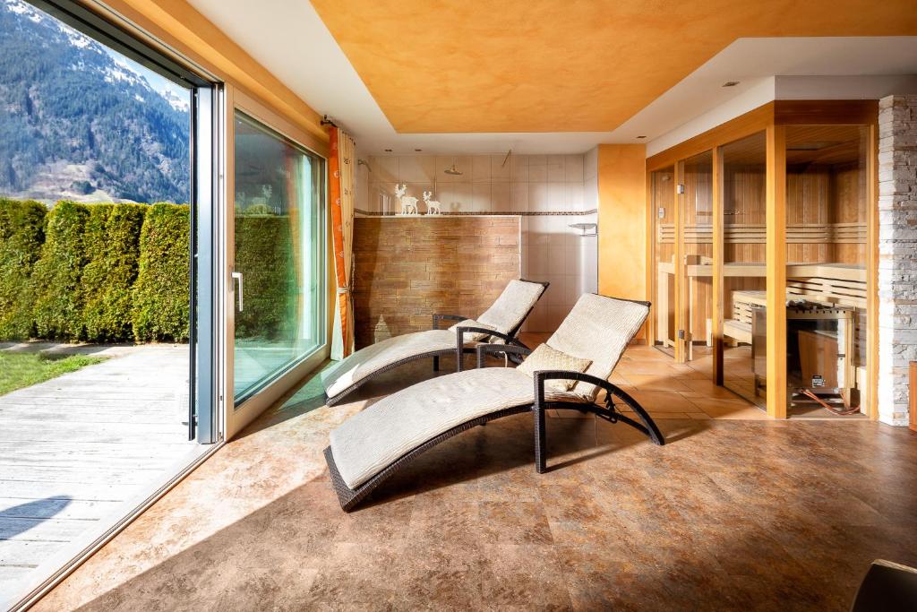Habitación con 2 sillas y ventana grande. en Appartement Mountainview, en Sankt Gallenkirch
