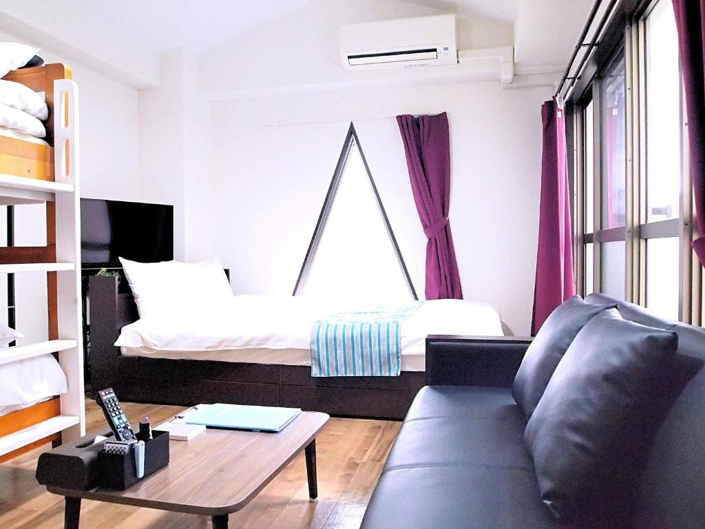 sala de estar con cama y sofá en COCOSTAY Matoba#902 ココステイ マトバ#902 広島駅徒歩10分 10 min walk from Hirosima Station, en Hiroshima