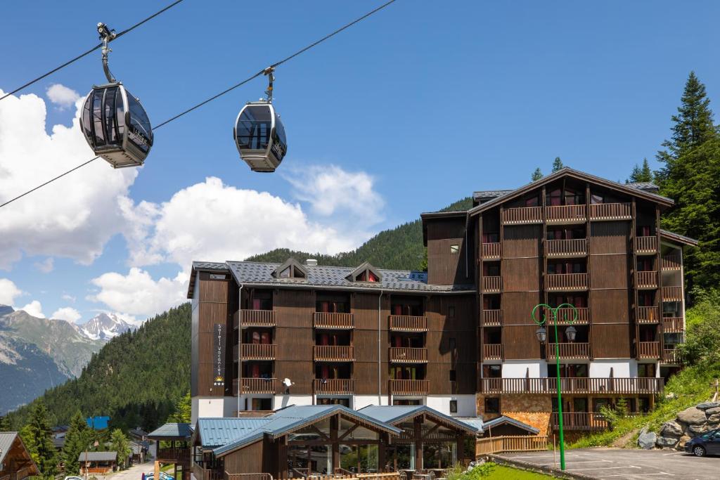 a large building with a ski lift in front of it at SOWELL Family Valfrejus in Valfréjus