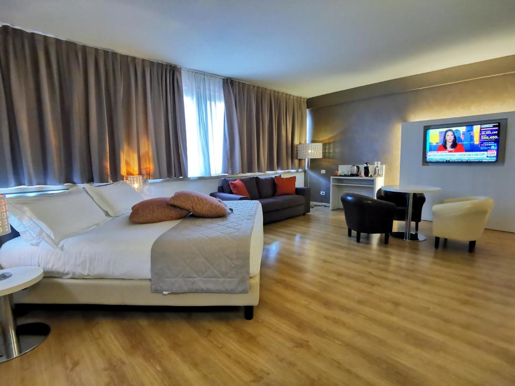 Habitación de hotel con cama y sala de estar. en Hotel President, en Prato