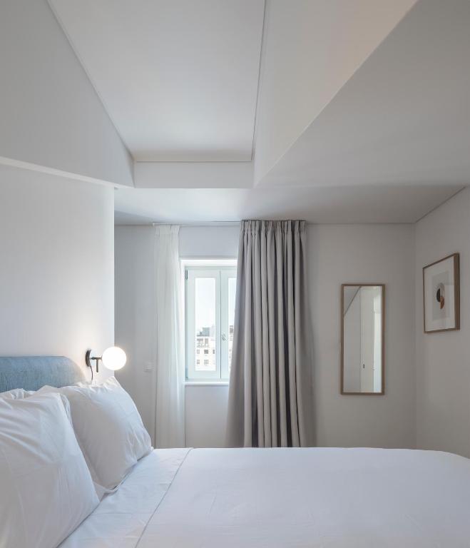 a white bedroom with a bed and a window at Lisbon Serviced Apartments - Mouraria in Lisbon