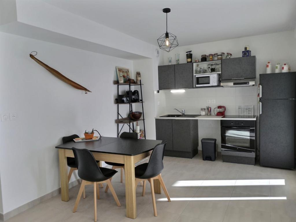 a kitchen with a table and chairs in a room at Appartement climatisé, moderne avec terrasses à 500m de la mer in Sérignan