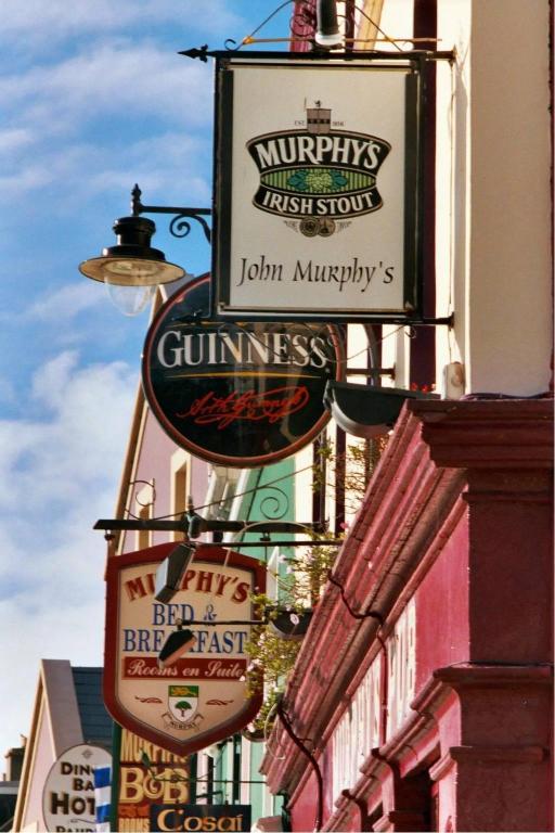 a bunch of signs on the side of a building at Murphy's Pub and Bed & Breakfast in Dingle