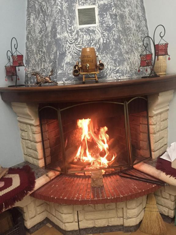 Una chimenea de ladrillo con fuego. en Vila Ridvani, en Korçë