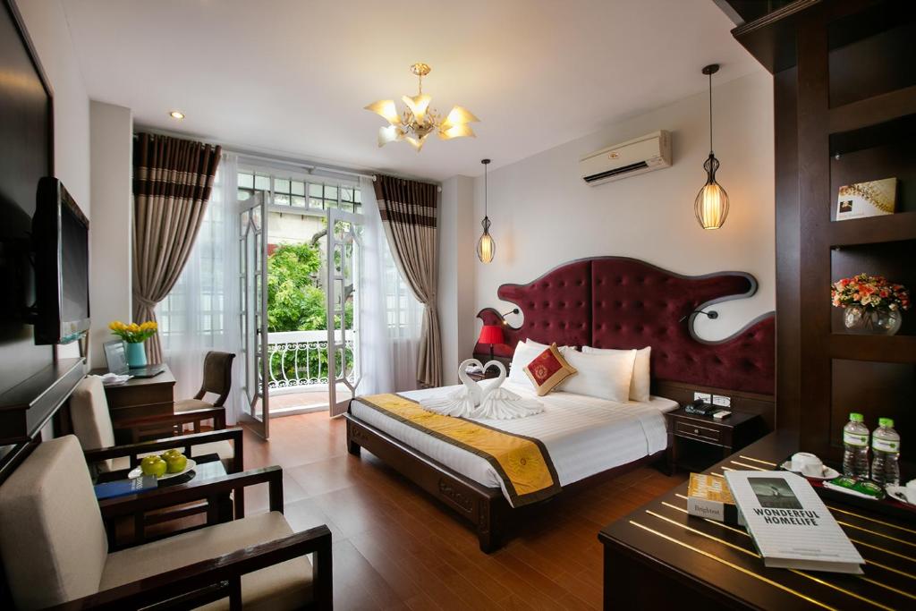 um quarto com uma cama grande e uma sala de estar em Labevie Hotel em Hanói
