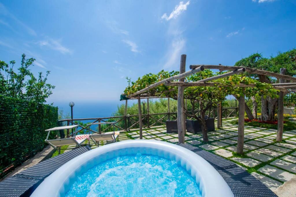 a hot tub in a backyard with a pergola at Holiday House Nuvola in Amalfi Coast in Furore