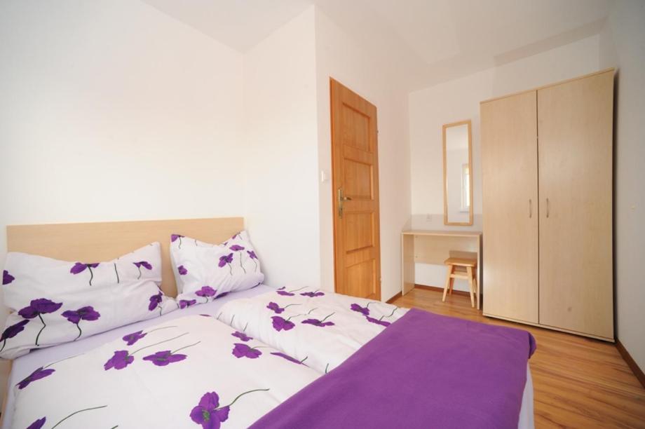 a bedroom with a large bed with purple sheets at Villa Arcadia in Sarbinowo