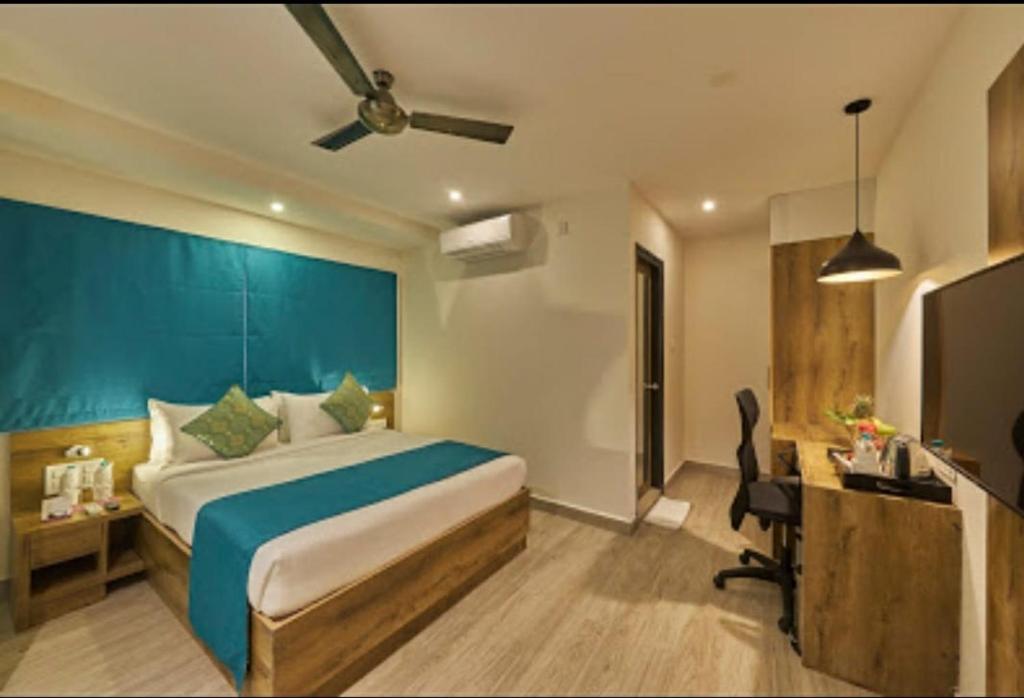 a bedroom with a large bed with a blue headboard at Regenta INN Grand Koramangala by Royal Orchid Hotels in Bangalore