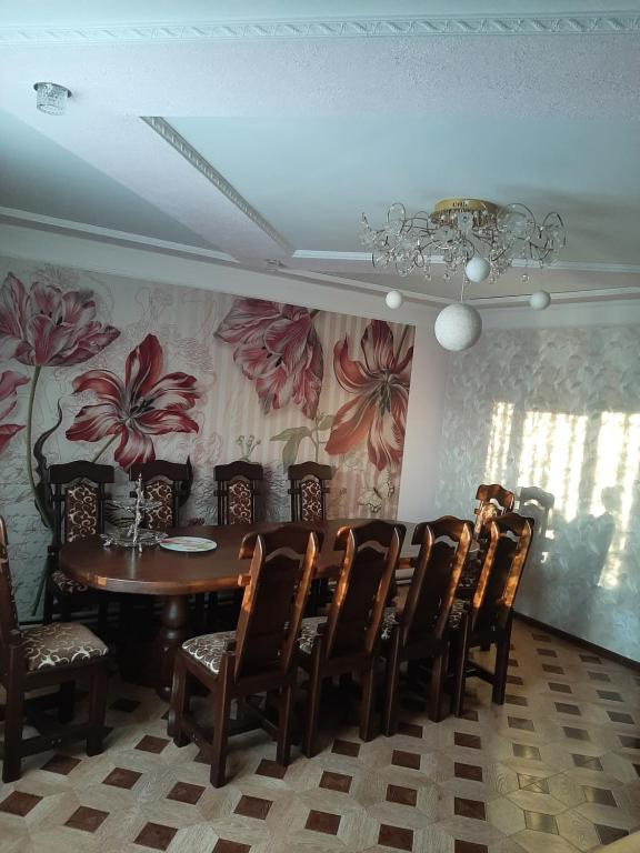 a dining room with a table and chairs and a chandelier at У Ані in Lazeshchyna