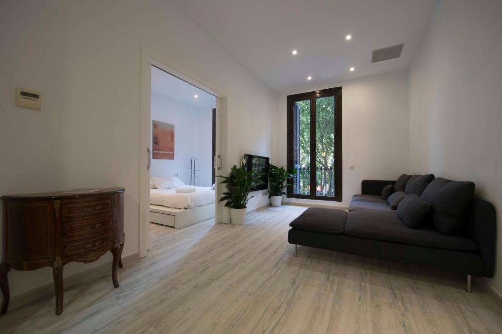 バルセロナにあるロヘル デ ユリア デザイン アパートメントのリビングルーム(ソファ付)、ベッドルーム1室が備わります。